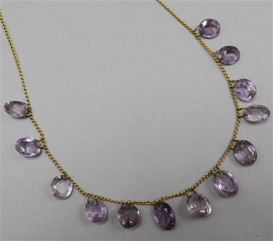 An amethyst necklace set with thirteen graduated oval cut stones, 42cm.